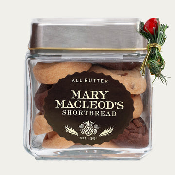 1 quart glass cookie jar filled with ~16 of mary macleod's all-butter, handcrafted shortbread cookies in an assorted flavour. Features a holiday / Christmas accent, evergreen and berry.