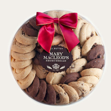 9 Inch Clear Transparent Round package of Mary Macleod's Shortbread with 36 premium artisanal gourmet signature assorted all-butter shortbread cookies, accented with our holiday red bow