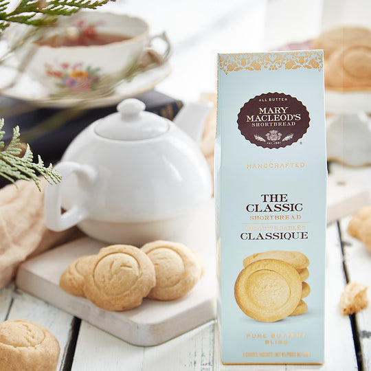 Blue Peaked gift box of plain traditional classic shortbread cookie beside a cup of tea