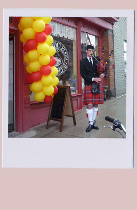 Bagpipe player outside of the storefront 